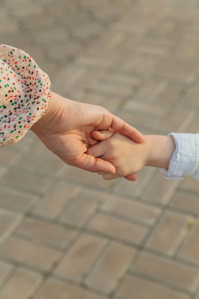 Mutter und Sohn halten Händchen.